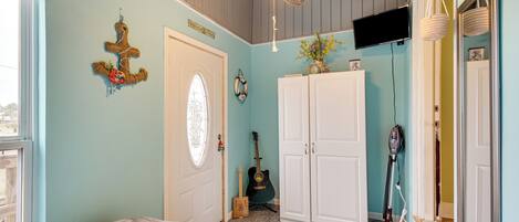 Un dormitorio con una cama, una guitarra, un aspirador y un televisor en la pared.