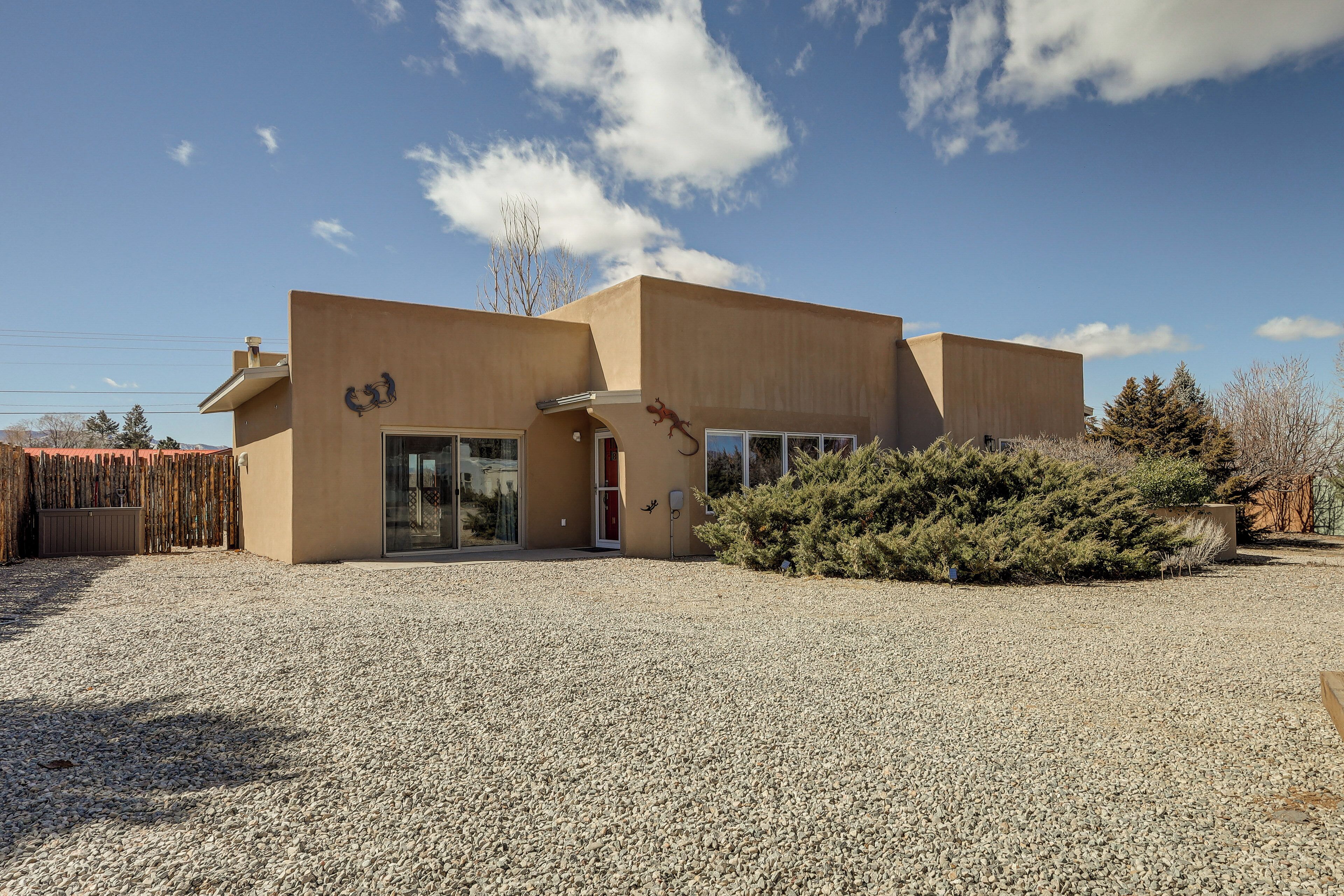 A modern building with a gravel driveway and a small garden area.