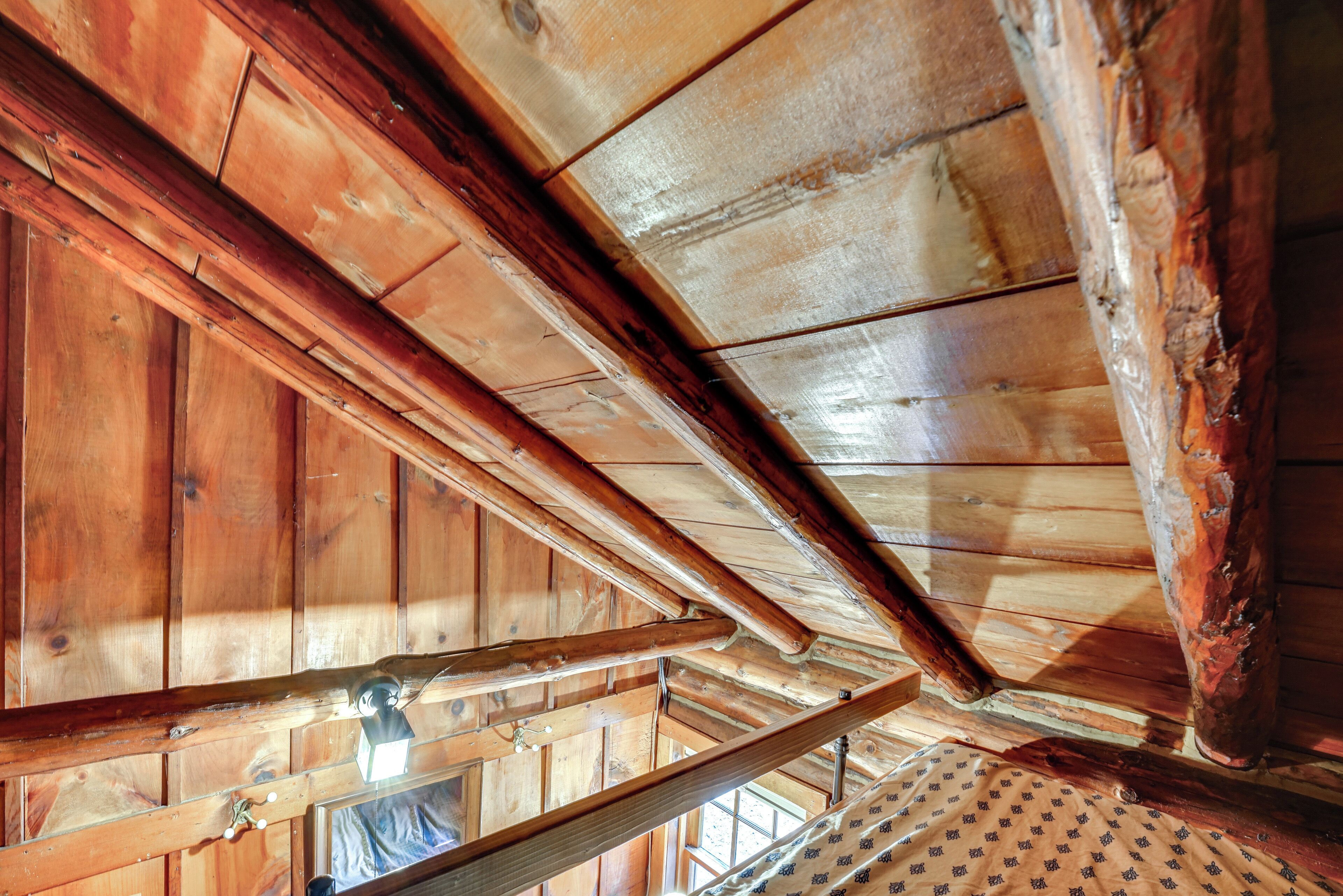 A wooden ceiling with exposed beams and a slanted roof.