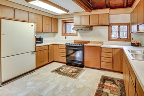 Kitchen features a central stove, refrigerator, microwave, and sink.