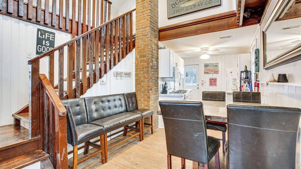 A spacious living area with a wooden staircase, a bench, and a dining table with chairs. - Wildwood Retreat w/ 2 Balconies: 5 Blocks to Beach (Wildwood)