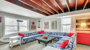 A living room with a blue and white patterned sofa, a white side table, a red dresser, and a wooden ceiling. - Wildwood Retreat w/ 2 Balconies: 5 Blocks to Beach (Wildwood)