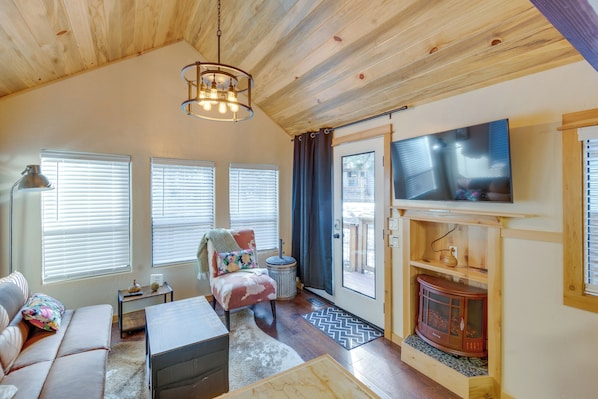 A cozy living room with a sofa, armchair, coffee table, and a fireplace. - Cozy & Restful Cabin, 2 Blocks to Lake Almanor (Westwood)