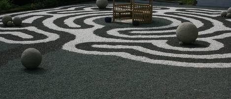 A gazebo surrounded by a circular gravel pattern with evenly spaced stones.