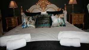 A neatly made bed with white linens, two decorative pillows, and two bedside tables with lamps. - High Dalby House (Pickering)