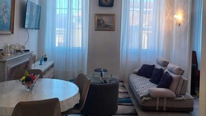 Una sala de estar con una mesa redonda de comedor, un sofá y un televisor.