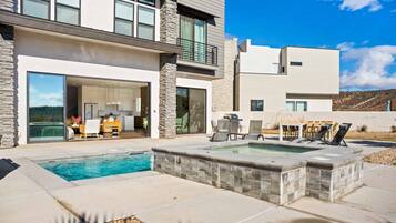 A modern two-story house with a swimming pool, outdoor seating, and a patio area.