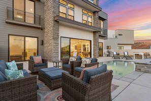 A modern house with a pool, outdoor furniture, and a dining area. - Perfectly On Par 7 Bedroom Home (Washington)
