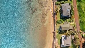 An aerial view of a coastal area with houses adjacent to a beach.