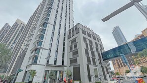 Un edificio alto y moderno con una entrada destacada y varios pisos.
