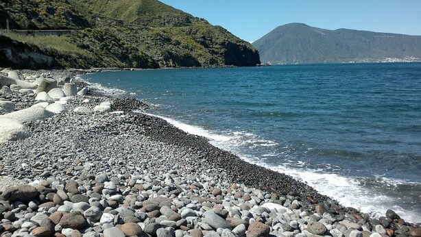 A rocky beach with a clear view of the sea and distant mountains. - Little house by the sea (Acquacalda)