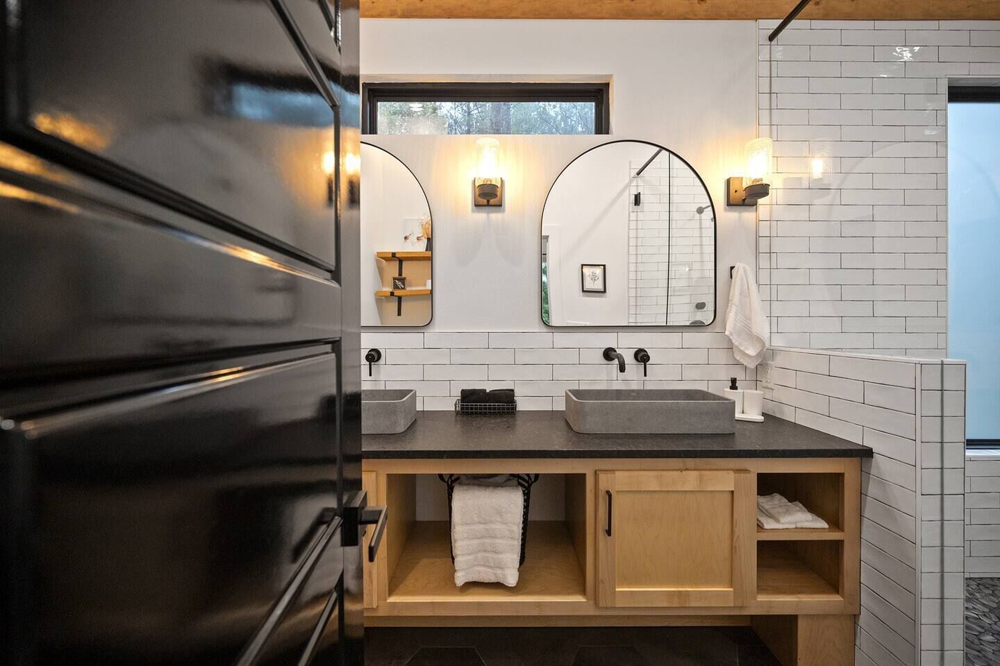 Un bagno moderno con doppio lavandino, due specchi e un porta asciugamani.