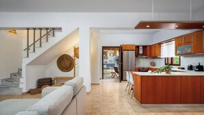 Eine moderne Küche mit Holzausstattung, einem Edelstahlkühlschrank und einer zentralen Kochinsel.
