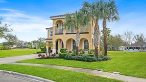A two-story house with a yellow facade, arched windows, and a balcony. - 6 Bedroom W/Private Pool! Spa! Near Disney! (Davenport)