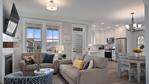 Uma sala de estar moderna com um sofá, mesa de centro e um espaço de jantar com mesa e cadeiras.