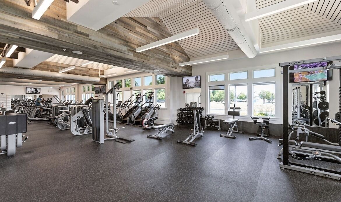 A gym with treadmills, elliptical machines, and weight equipment.