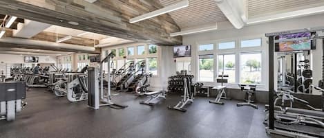 Een sportschool met loopbanden, elliptische trainers en gewichttoestellen.
