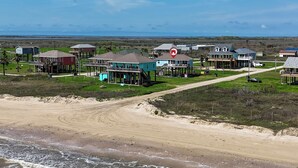 Une propriété située sur la côte, avec des maisons donnant sur la plage, un chemin de terre et une plage.