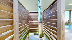 Un intérieur en bois avec une colonne centrale, un élément décoratif en métal et un sol en béton.