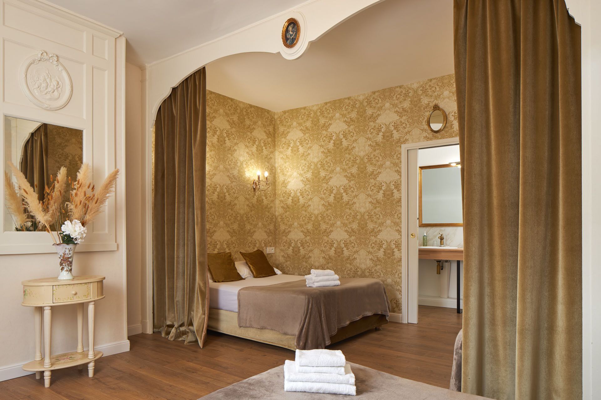 A bedroom with a bed, a vanity with a mirror, and a nightstand.