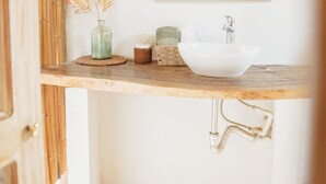 A bathroom with a wooden vanity, a white sink, and a mirror above it. - Villa el Oasis (Santa Marta)