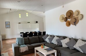 Relax in this stylish living space with a large sofa, coffee table, and dining area.