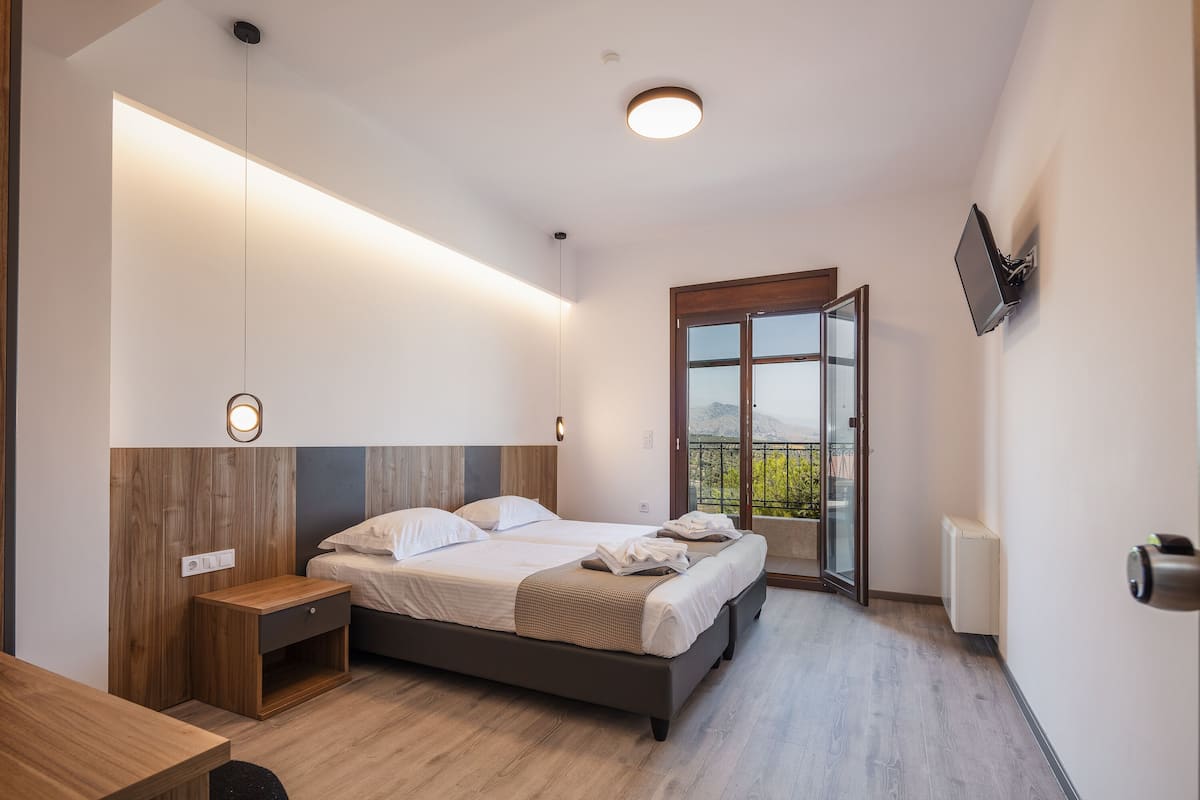 Un dormitorio moderno con cama, mesita de noche y vistas al exterior.