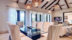 Una sala de estar moderna con una mesa de centro de vidrio, sofás color beige y un televisor.