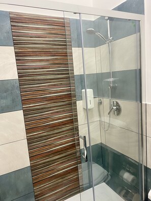 Klassiek appartement | Badkamer | Een douche, een regendouche, een haardroger, een bidet