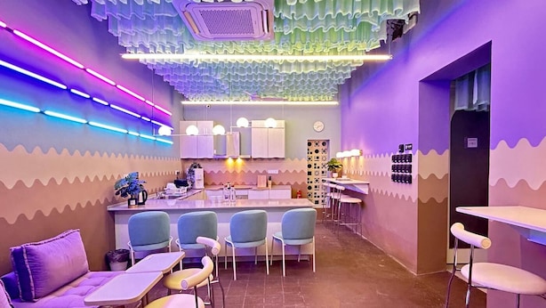 A modern bar with a unique ceiling design, bar stools, and a counter with a plant. - Urban Designer Collection Lebuh Melaka (George Town)
