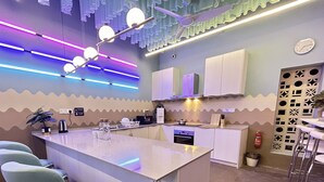 A modern kitchen with a central island, white cabinets, and a ceiling fan. - Urban Designer Collection Lebuh Melaka (George Town)