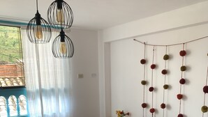 A bedroom with a bed, a patterned blanket, hanging light fixtures, and a wall decoration. - Cozy apartament in the most popular and colorful artesans street in Pisac (Písac)