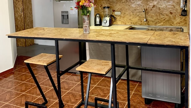 A compact kitchen with a wooden countertop, a sink, and a built-in refrigerator. - Cozy apartament in the most popular and colorful artesans street in Pisac (Písac)