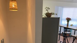 A staircase leading to a bright room with a dining area, a refrigerator, and a potted plant. - Cozy apartament in the most popular and colorful artesans street in Pisac (Písac)