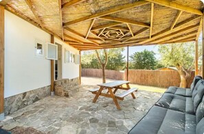 Relax in a serene garden setting with a picnic table and comfortable sofa.