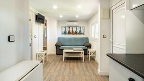 Un espacio habitable pequeño con sofá, mesa de centro y una mesita auxiliar.