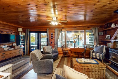 1-acre lakefront log cabin with dock, 50 ft water frontage, hot tub, & deck