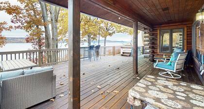 1-acre lakefront log cabin with dock, 50 ft water frontage, hot tub, & deck