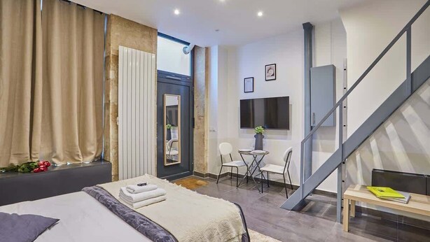 Ein modernes Hotelzimmer mit einem großen Bett, einem Schreibtisch und einer Treppe.