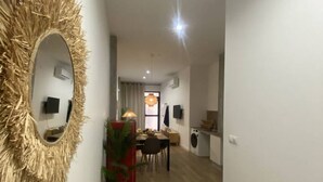 A modern kitchen with a dining area, a large mirror, and a potted plant. - A (VA070.2.9) TH Mediterranean Suites 9 (Valencia / València)