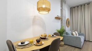 A dining area with a wooden table, chairs, and a hanging light fixture.