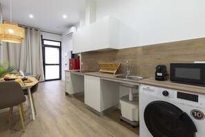 A modern kitchen with a washing machine, a microwave, and a sink.