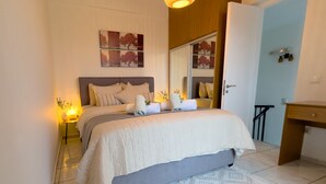 A neatly arranged bedroom with a bed, bedside lamps, a mirror, and a dresser.