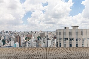 A cityscape with a tiled rooftop and a building with circular windows. - Akile Homes experiences Geek (São Paulo)