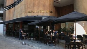 Un área de estar al aire libre de un restaurante con mesas y sombrillas.