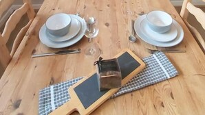 Ein Holztisch komplett mit Tellern, Gläsern und Besteck.
