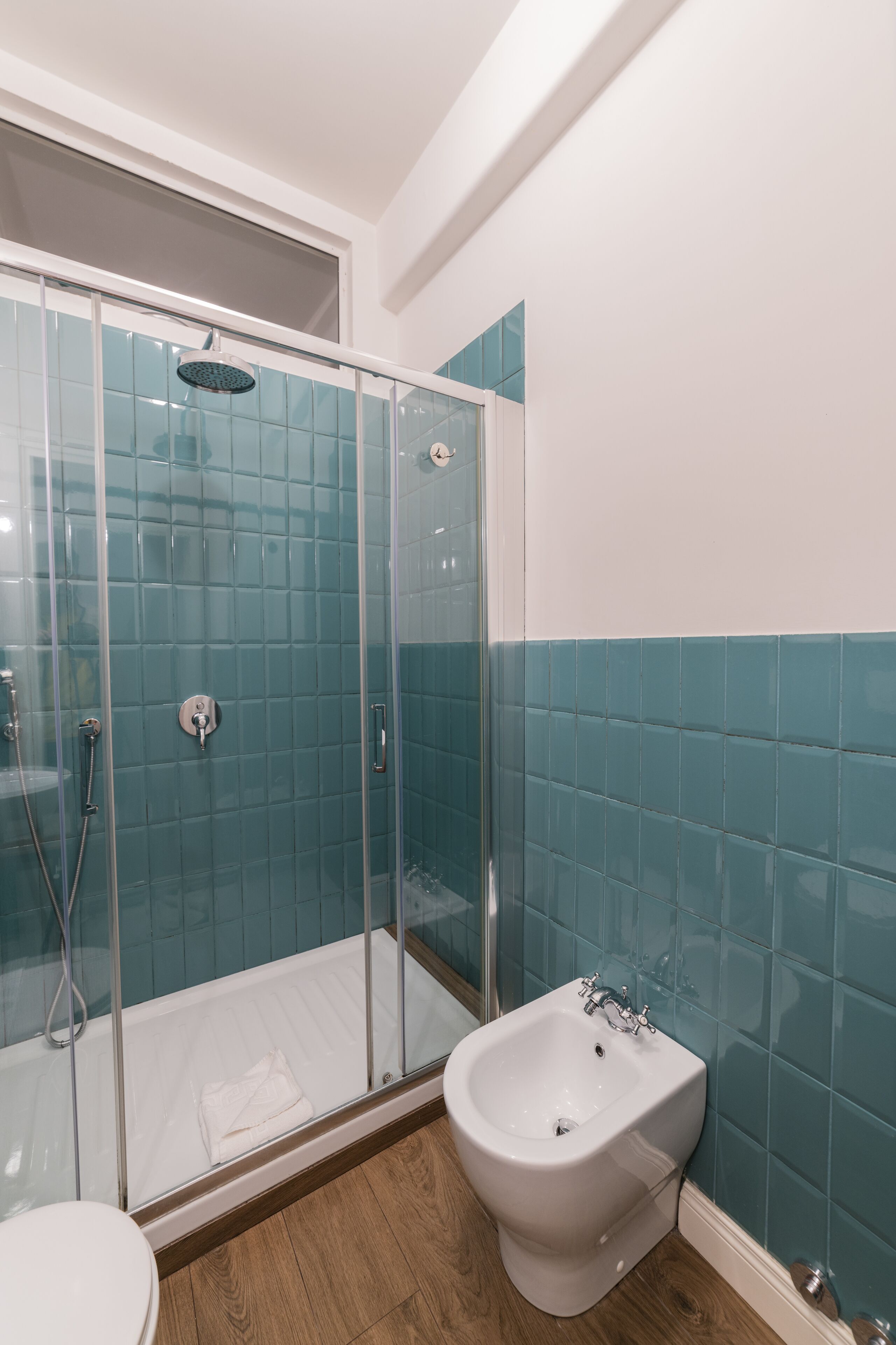 Ein Badezimmer mit einer Duschkabine, einem Bidet und einer Toilette.