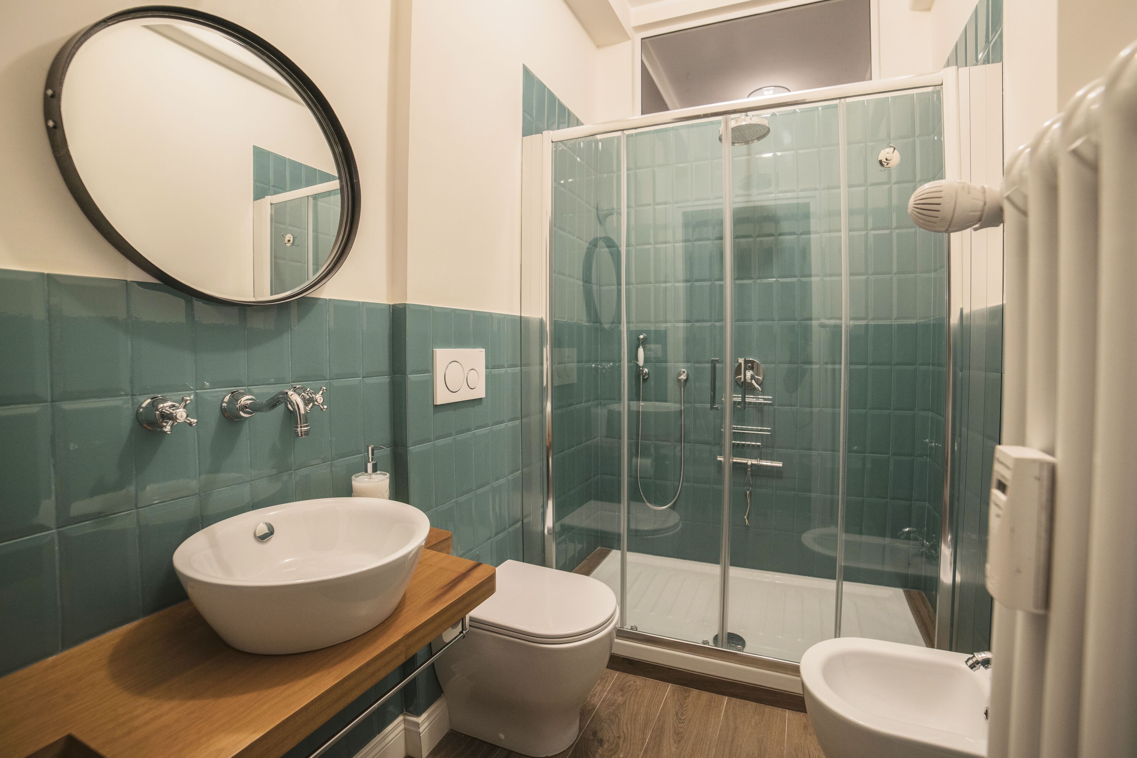 A bathroom with a white sink, a toilet, and a glass-enclosed shower.