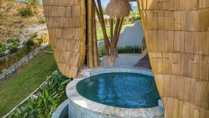 A modern house with a unique curved design, featuring a pool and lush garden. - Anima Eco Lodge (Kuta)