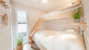 A bedroom with a bunk bed, wooden walls, a window with blinds, a ladder, and a potted plant. - Hausboot Rán für 5 Pers. mit Großzügiger Dachterrasse in Kragenæs auf Lolland (Schleswig)